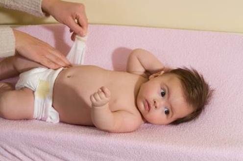 Description: Prepare a comfortable area to change the diaper for the baby by setting up a table for changing diaper or put a cloth on a soft, warm surface.