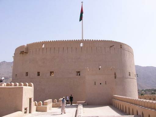 Description: The Nizwa Fort stands tall proudly carrying Oman’s flag on its crown