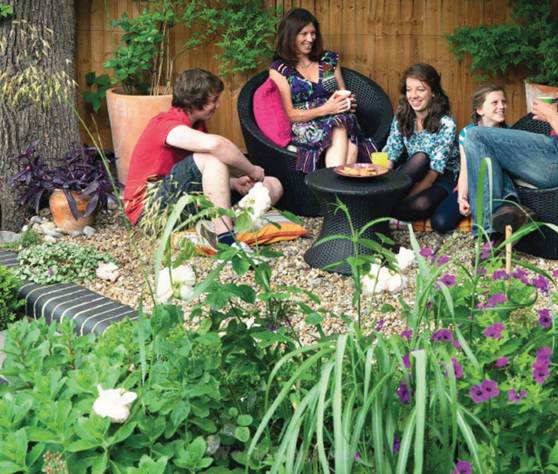 Description: The Monaghan family relax in a secluded seating area at the end of the garden