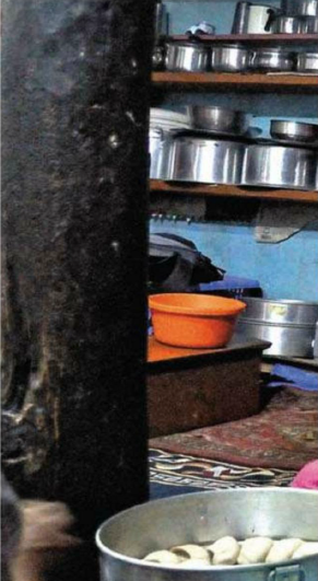 Description: Dolma and our guide Kunga prepared dinner in a cozy kitchen of Khabrick Homestay at Lhalung.